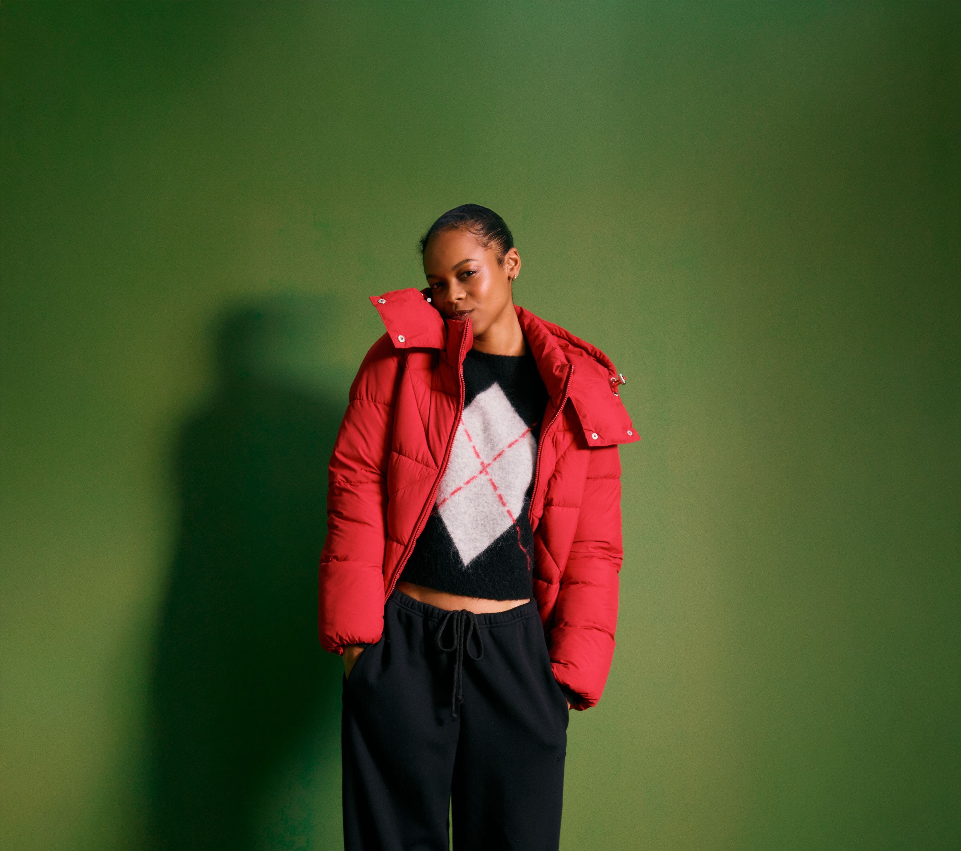 Woman wearing a puffer, sweater and sweatpants.