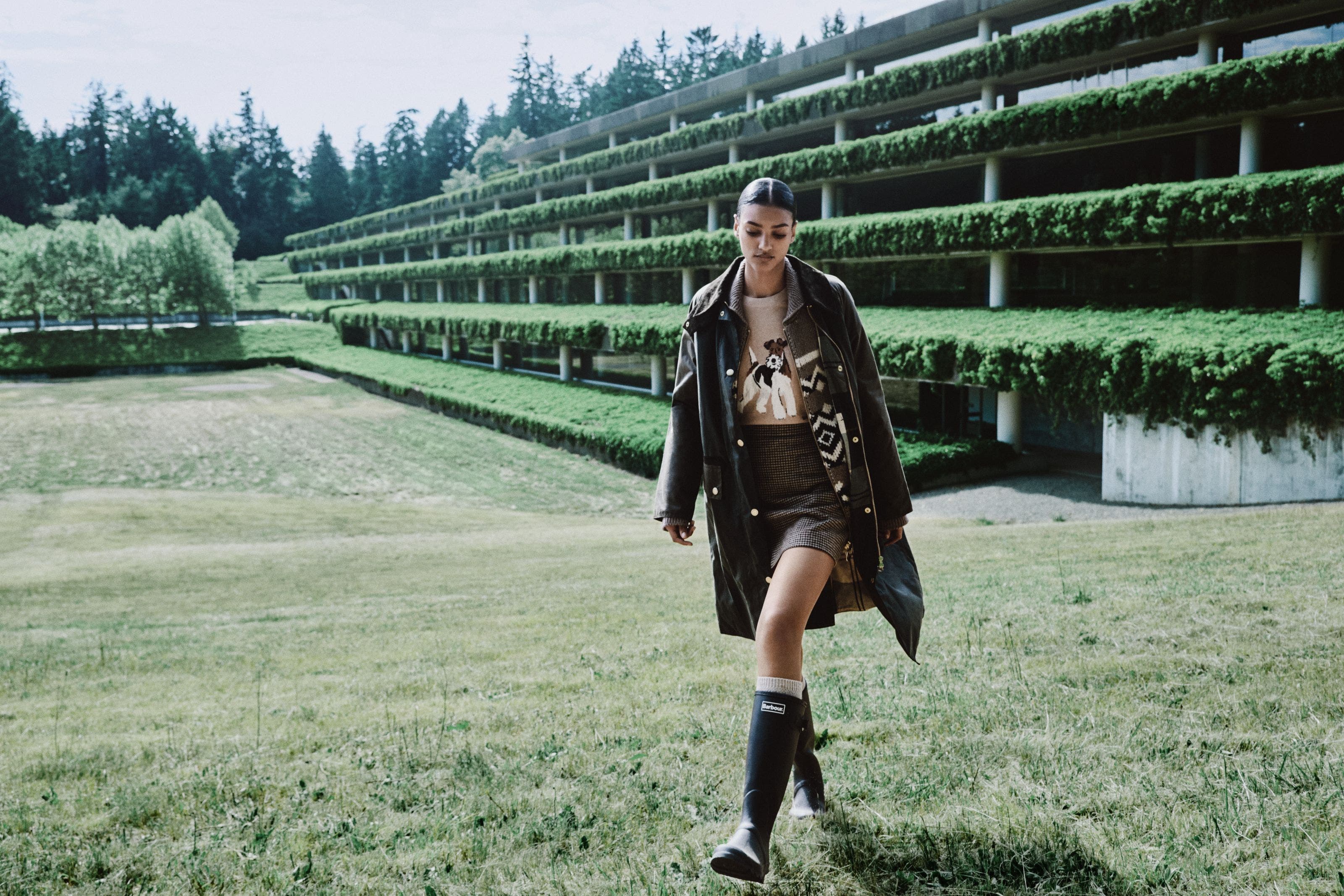 Woman wearing a bomber jacket, tiered skirt, bucket bag and boots.