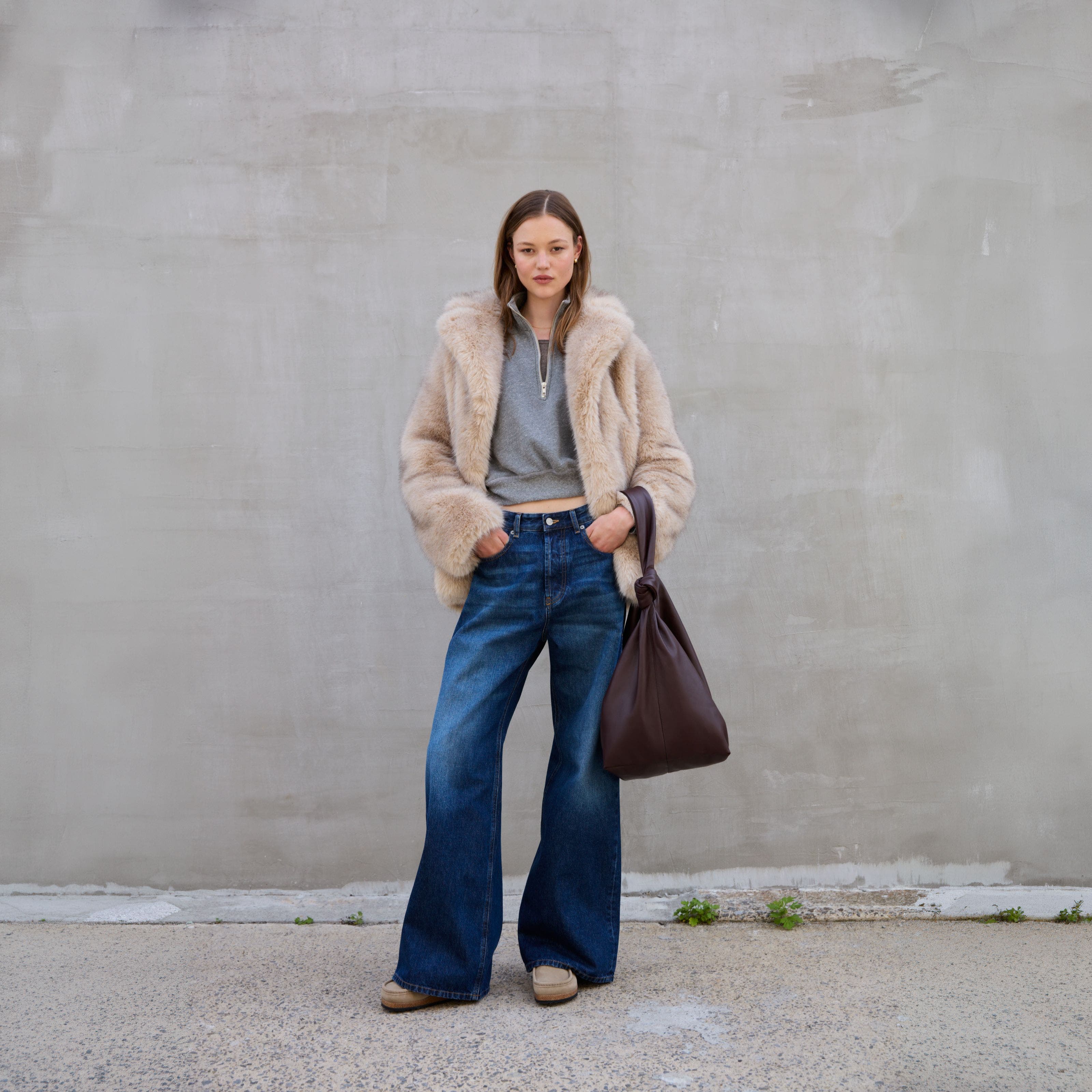 A woman wearing a fuzzy jacket and jeans.
