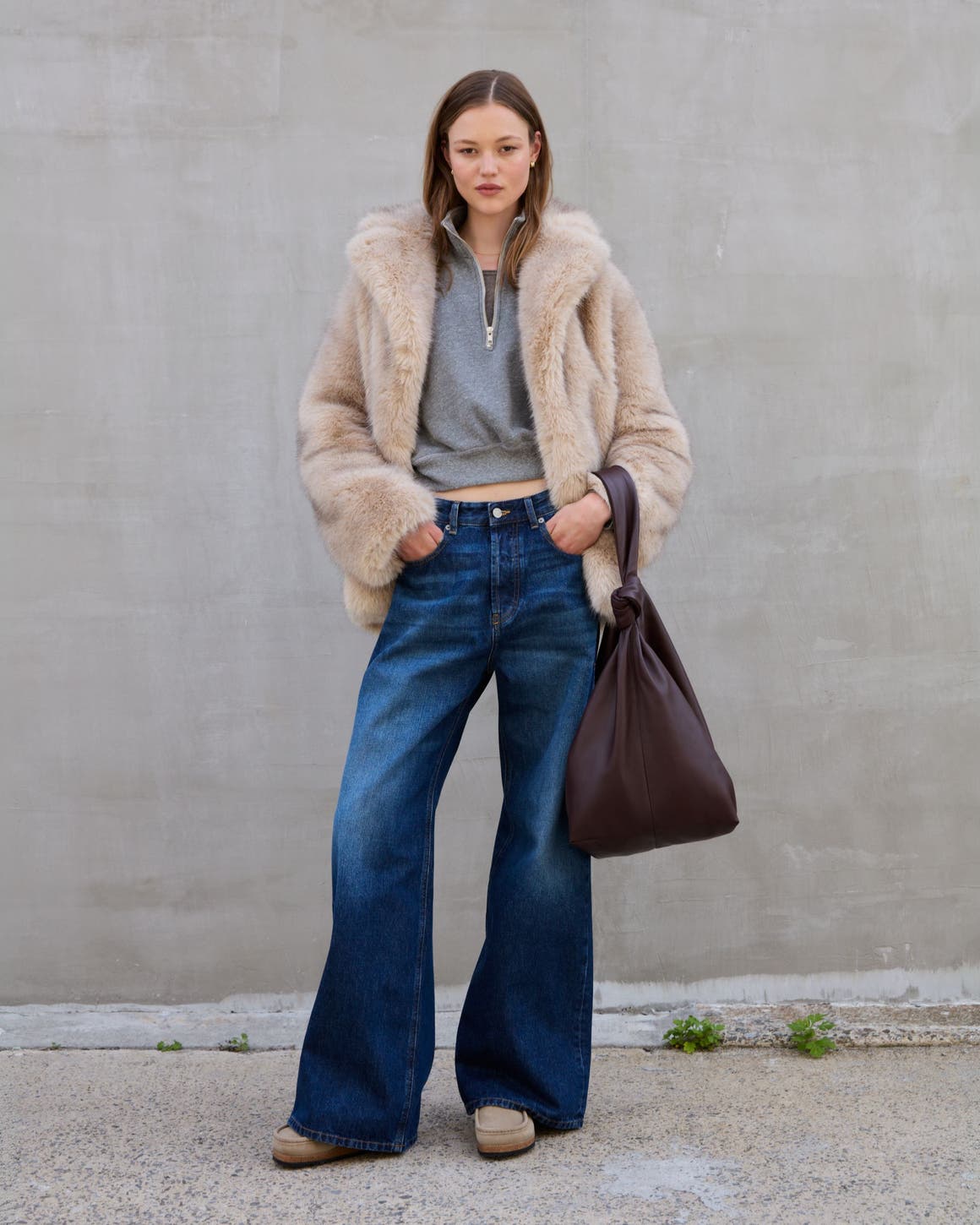 A woman wearing a fuzzy jacket and jeans.