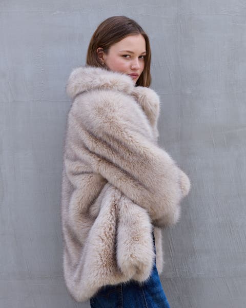 A woman wearing a tan faux fur jacket.