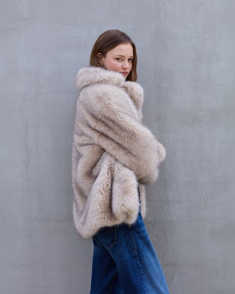 A woman wearing a fuzzy jacket and jeans.