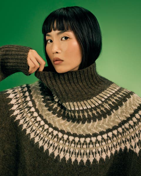 Woman in an olive turtleneck sweater.