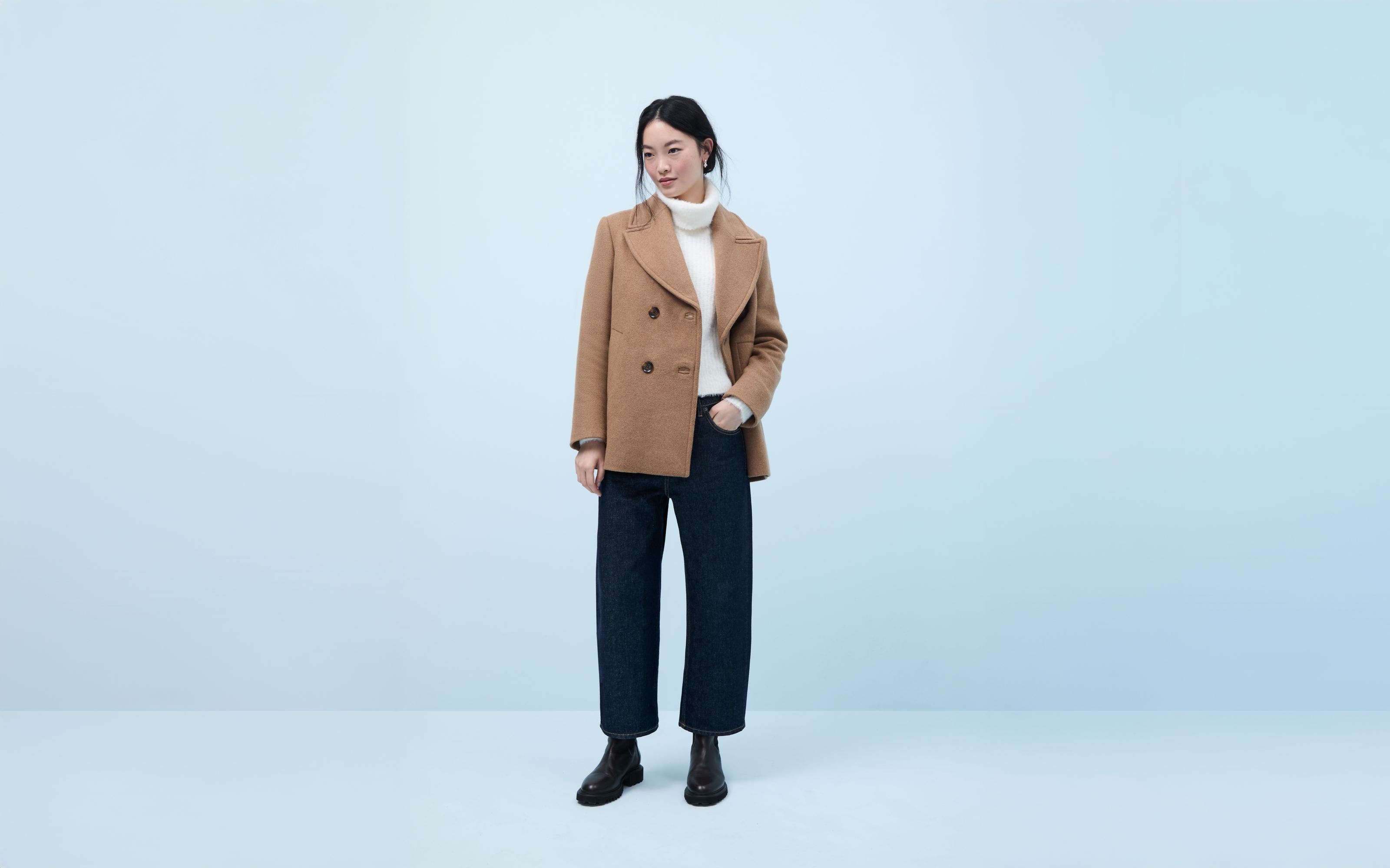A woman wearing a tan pea wool coat.