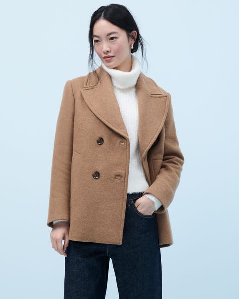 A woman wearing a tan pea wool coat.