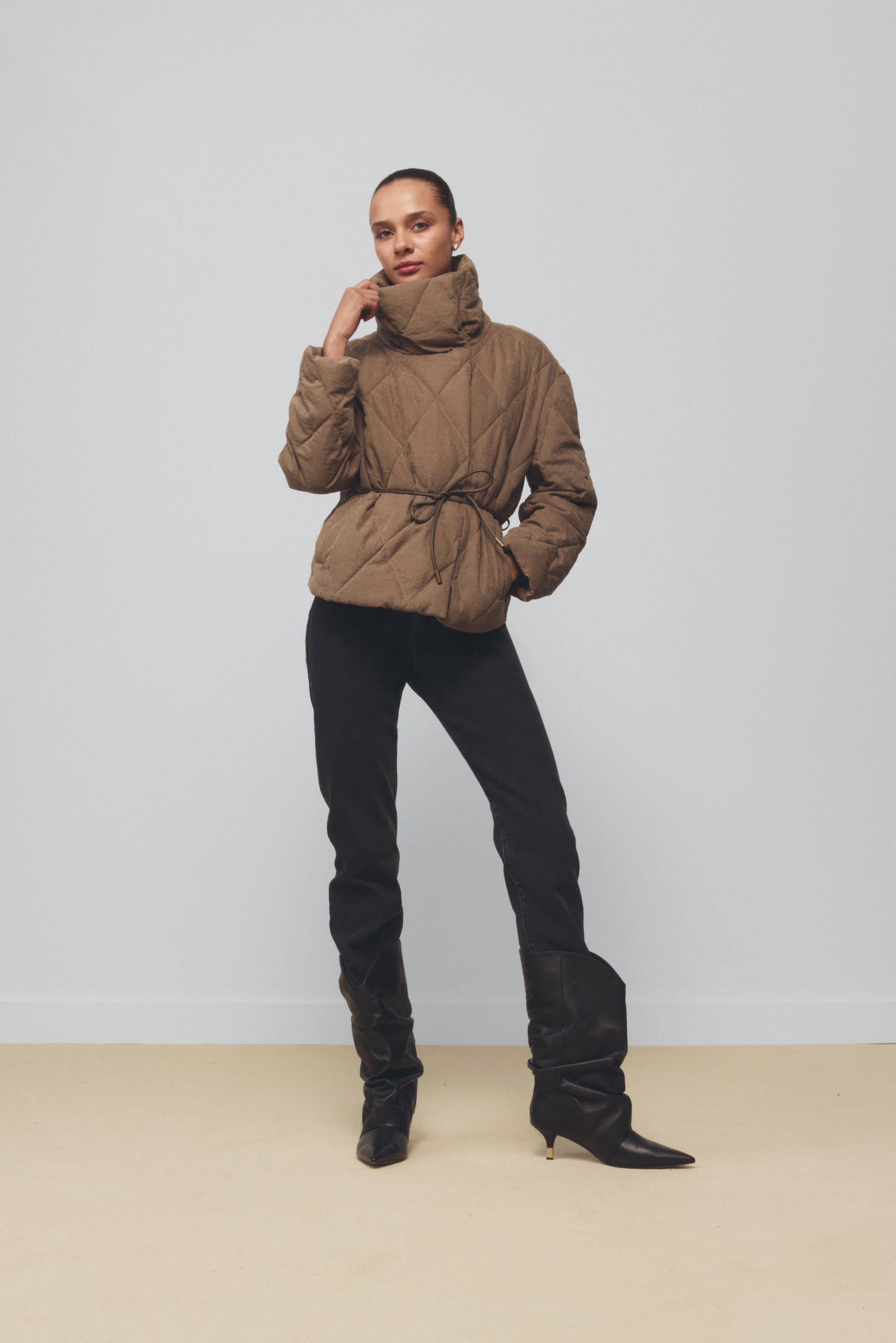 A woman wearing a high-collar jacket.