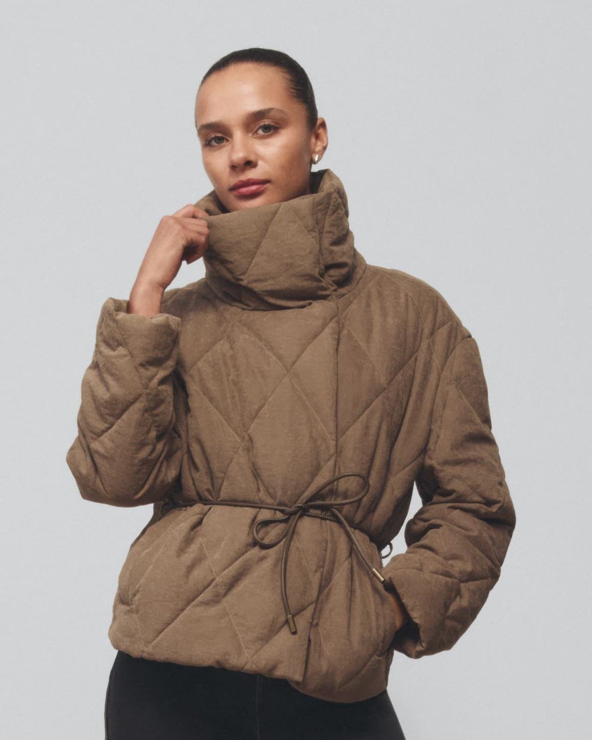 A woman wearing a high-collar jacket.