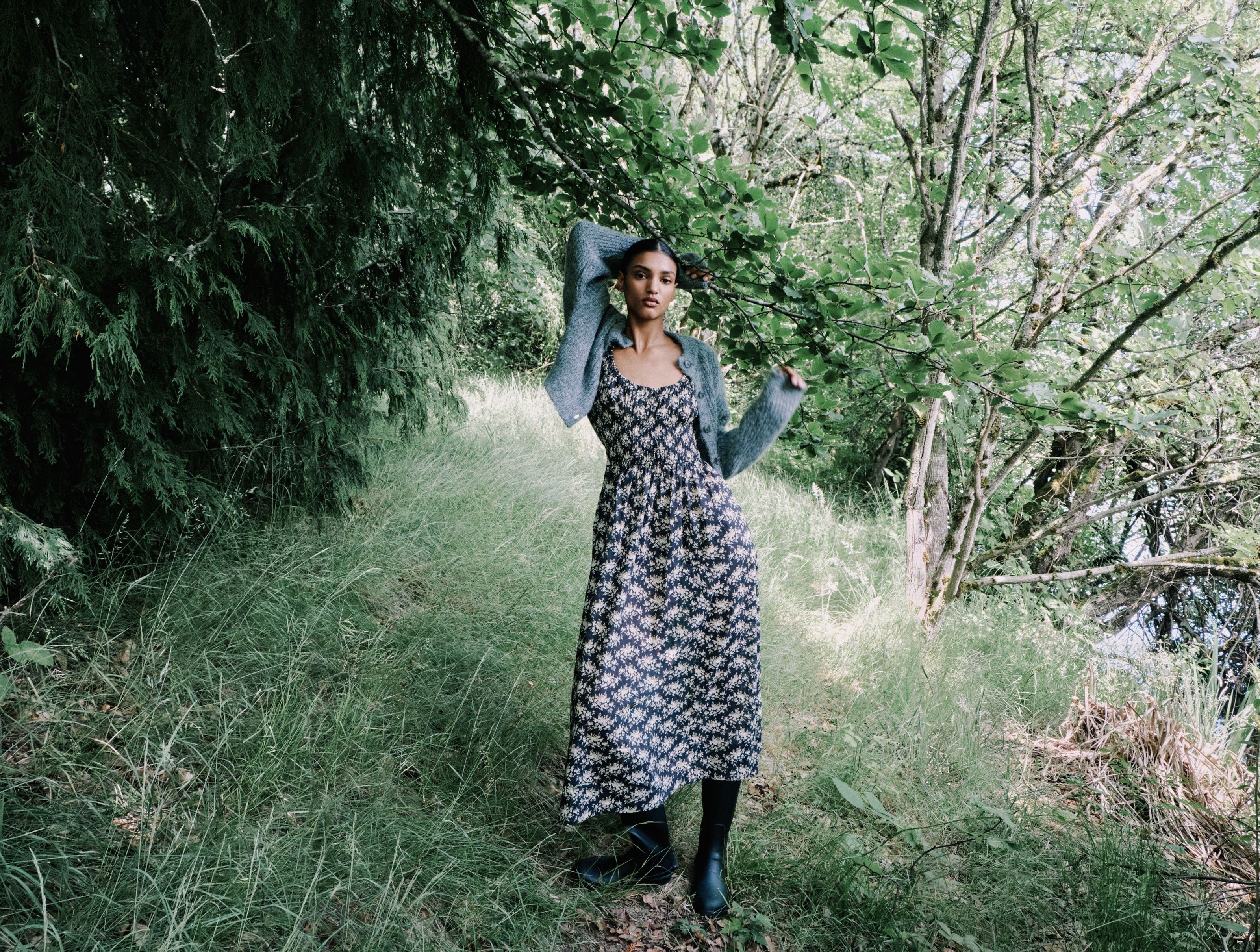 A woman holding onto a tree branch.