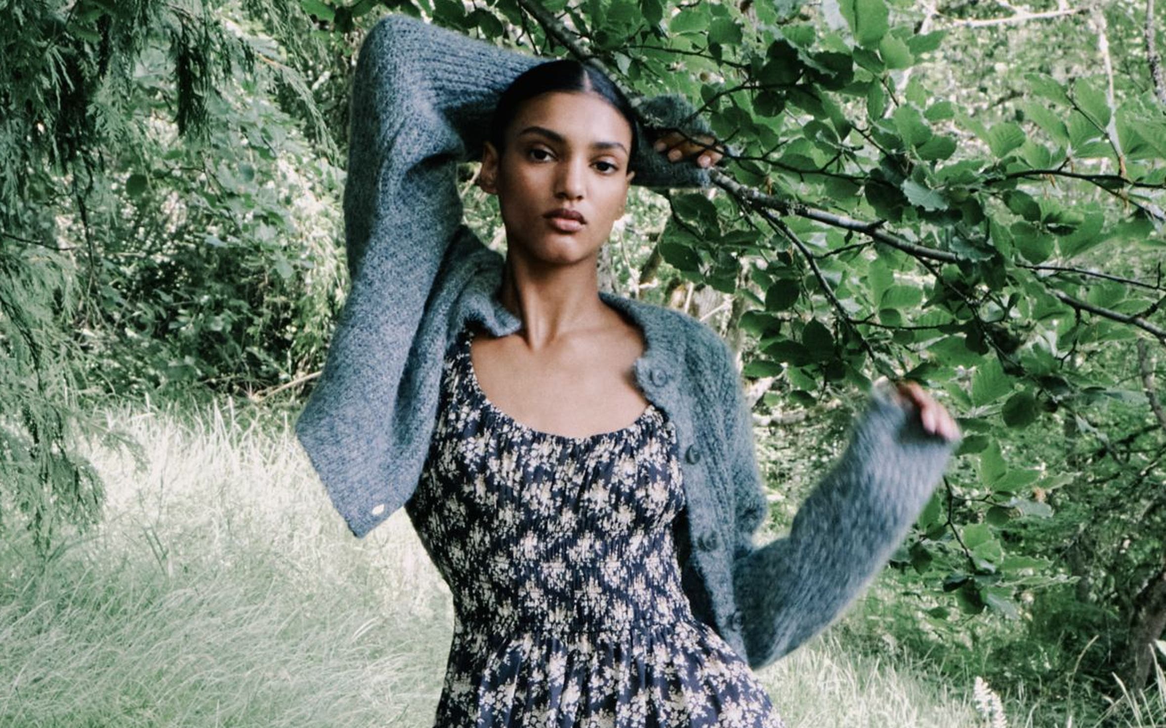 A woman holding onto a tree branch.