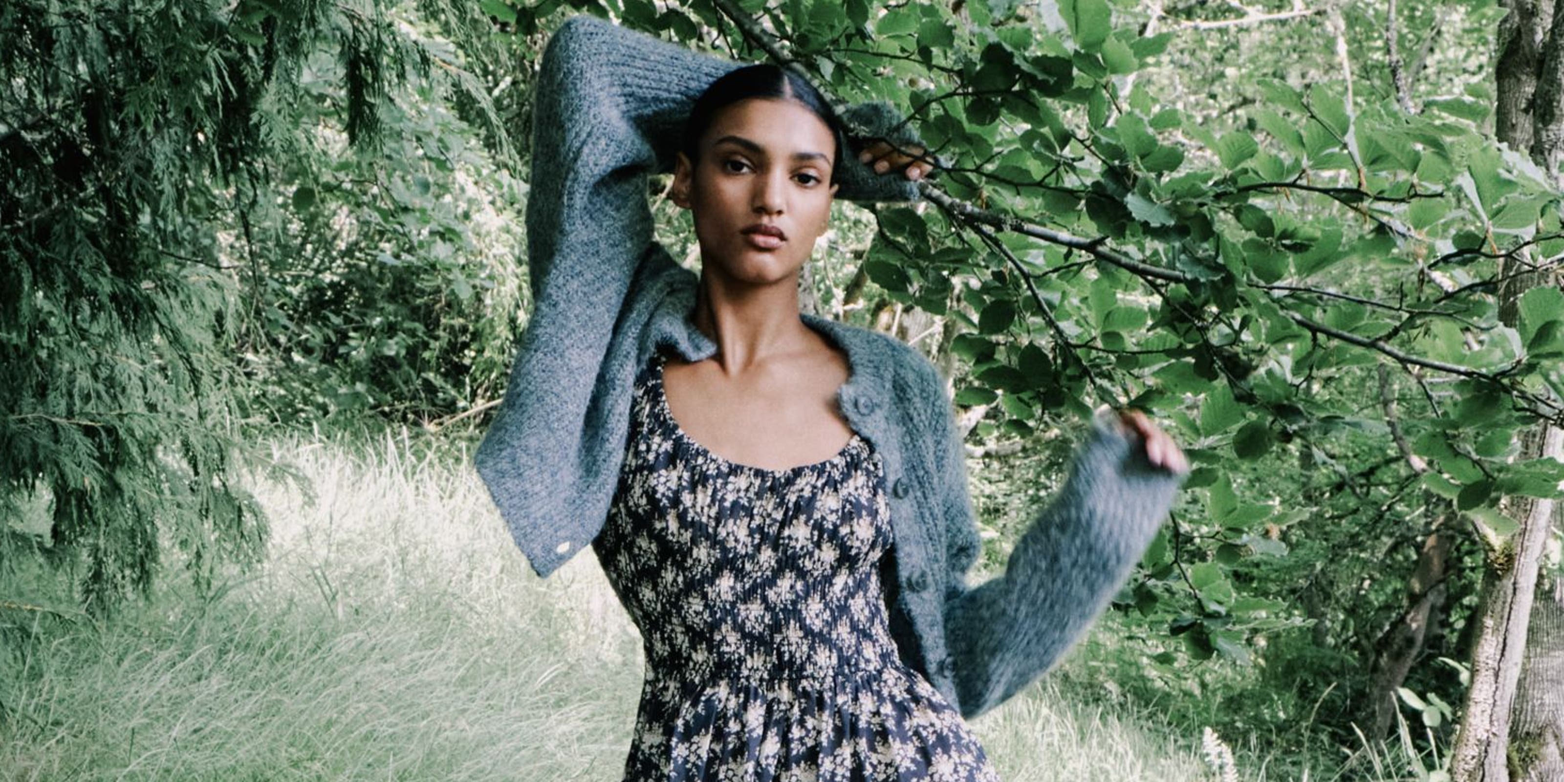 A woman holding onto a tree branch.