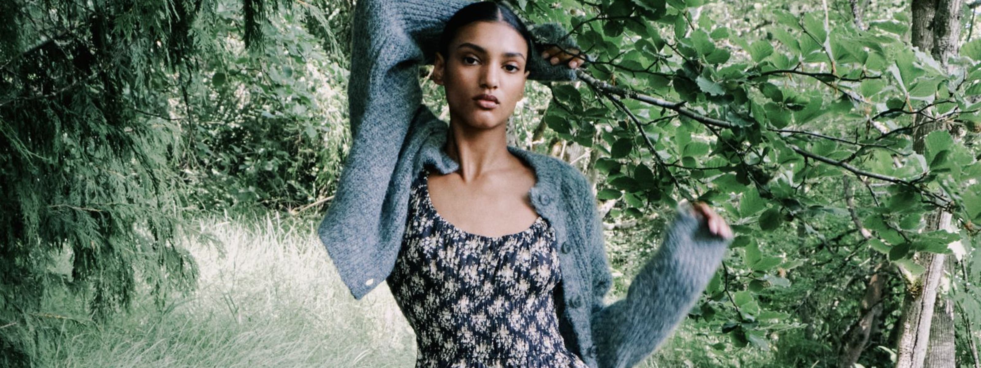 A woman holding onto a tree branch.