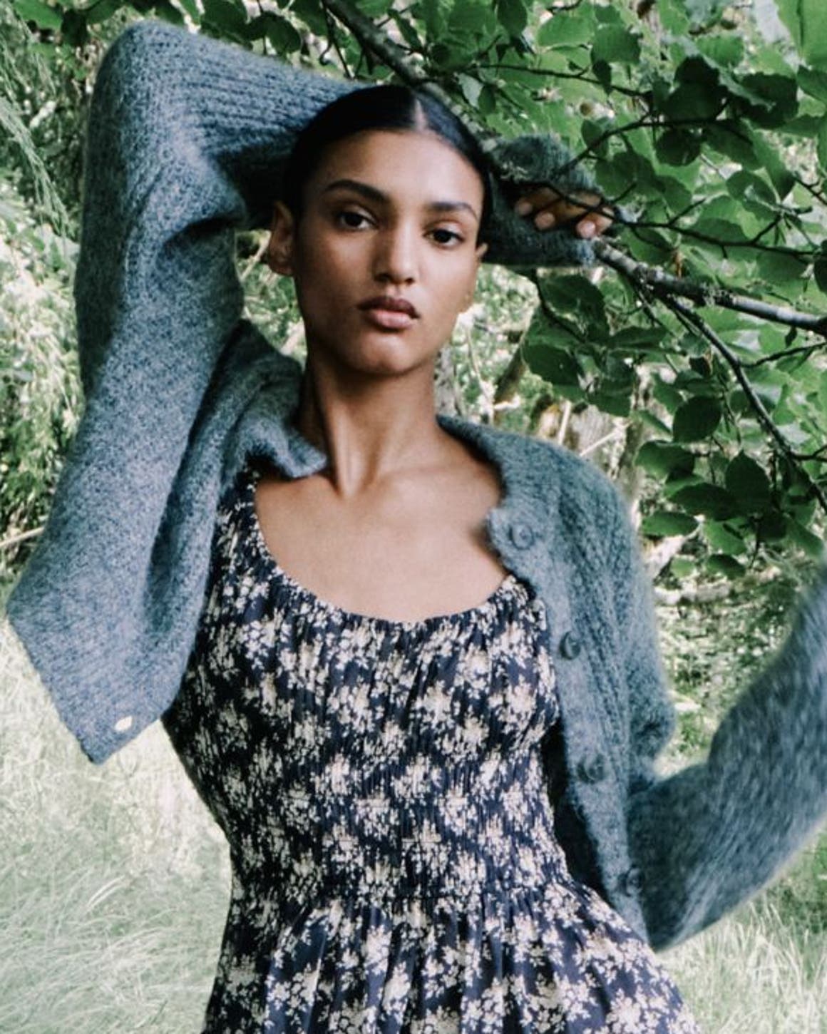 A woman holding onto a tree branch.
