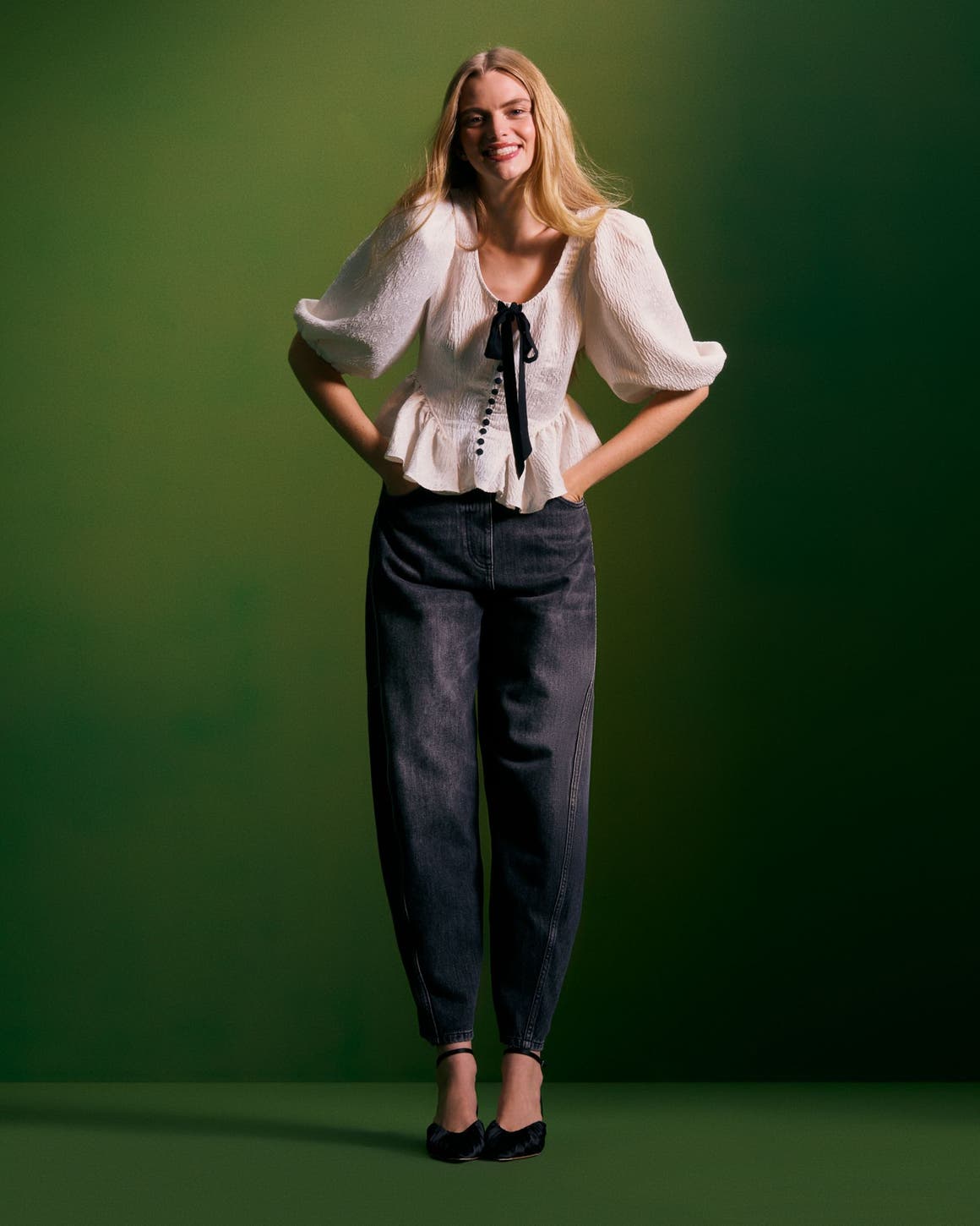Woman wearing a holiday party top, jeans and heels.