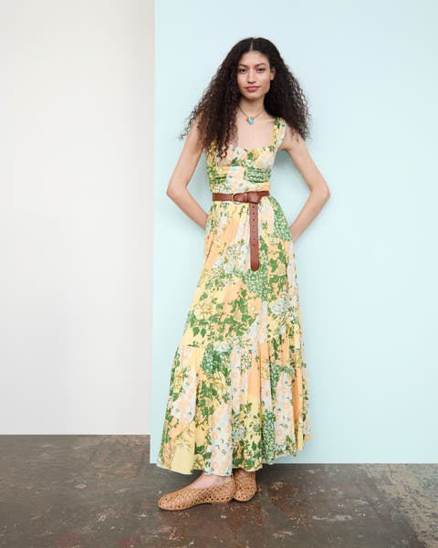 Woman wearing a green and yellow flower sundress.