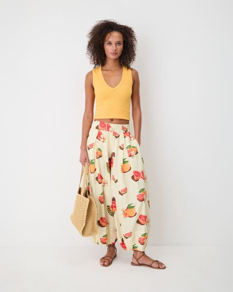 Woman wearing a yellow tank top with moonflower balloon pants.