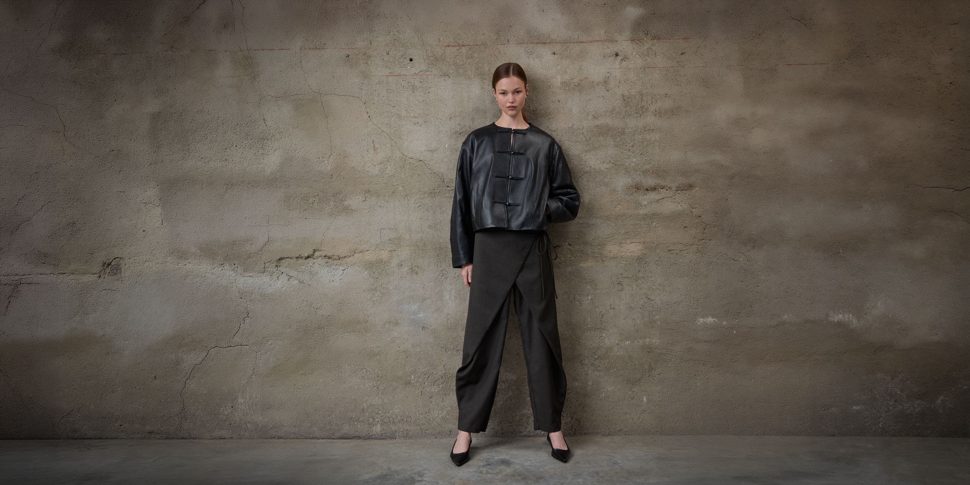 A woman wearing a leather jacket and trousers.