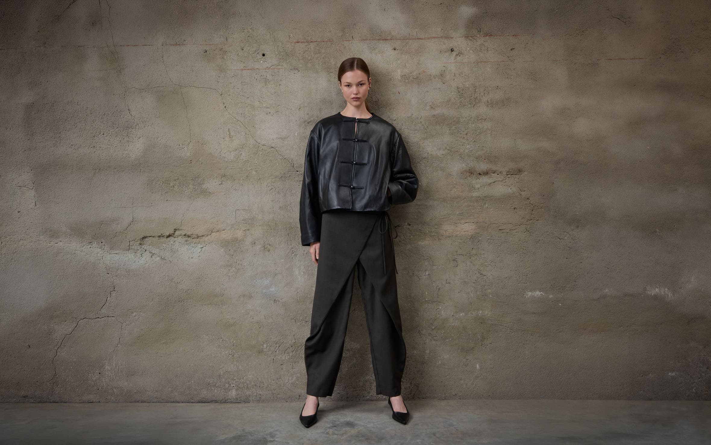 A woman wearing a leather jacket and trousers.