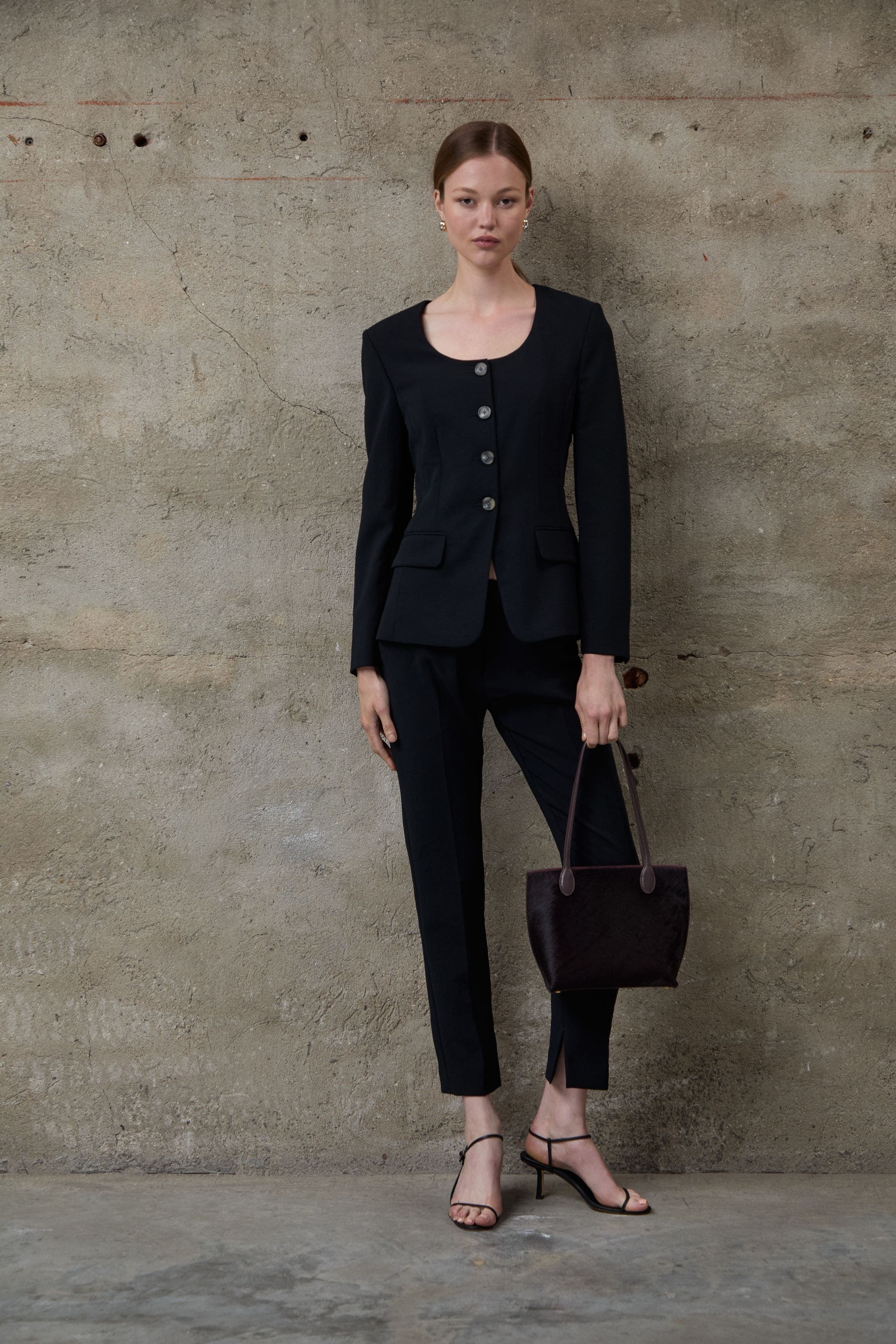 A woman wearing a suit jacket and trousers.