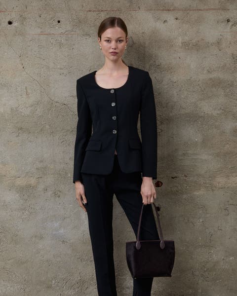 A woman wearing a suit jacket and trousers.