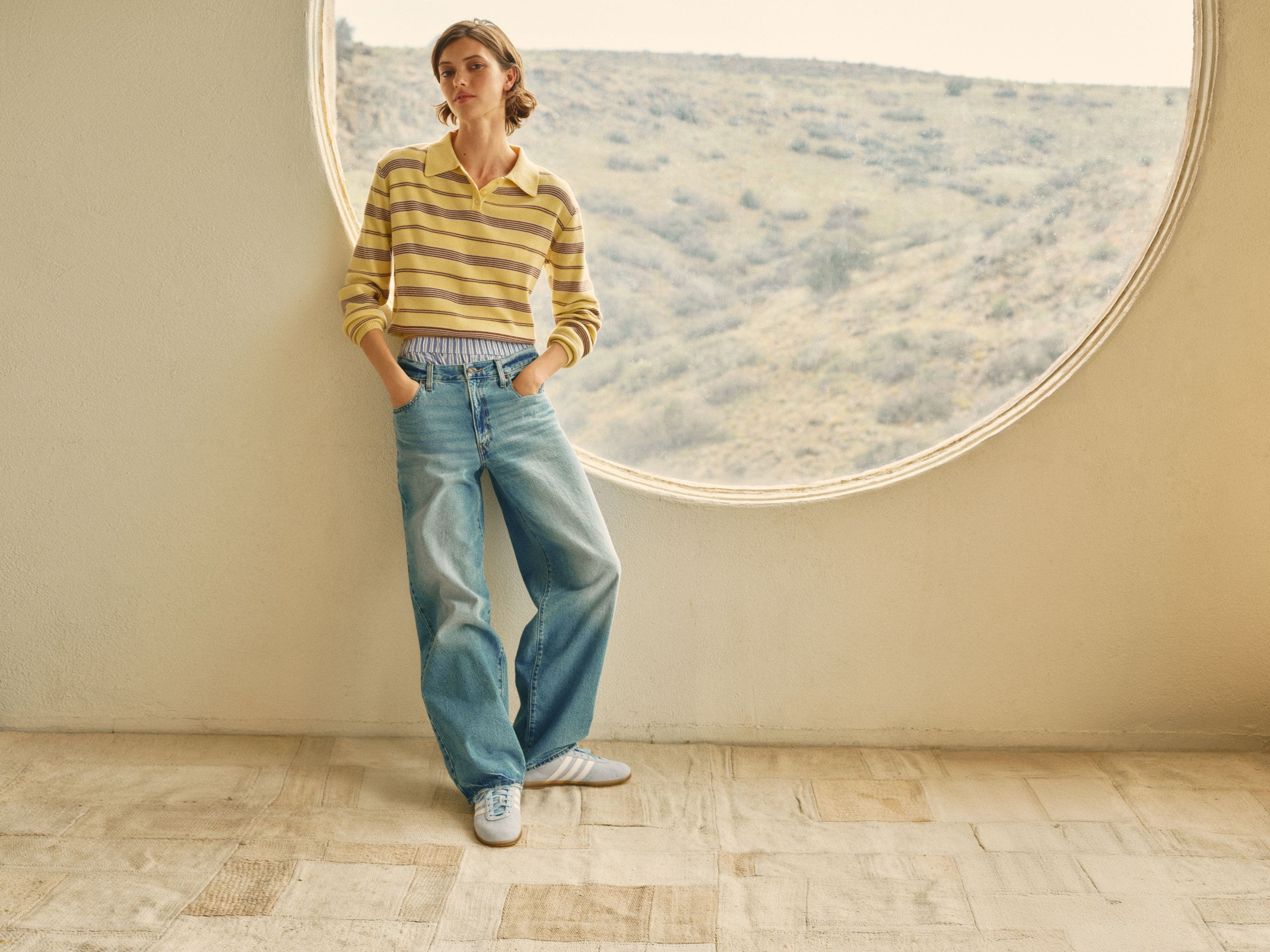 A woman wearing a striped top and baggy jeans.