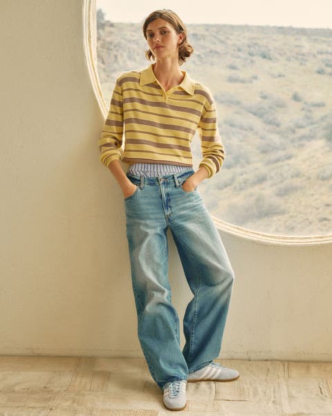 A woman wearing a striped top and baggy jeans.