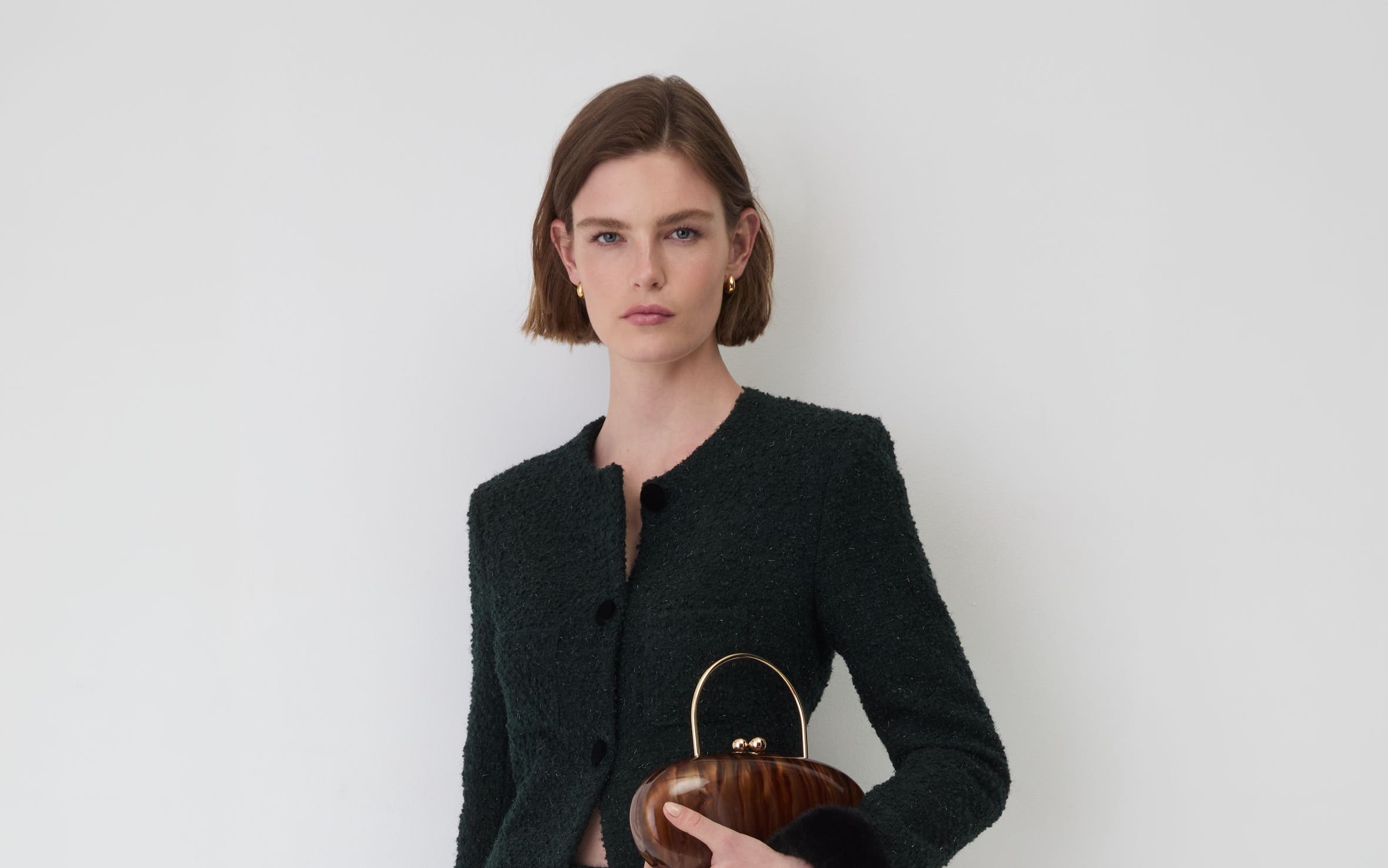 A woman wearing a black blazer and shorts.