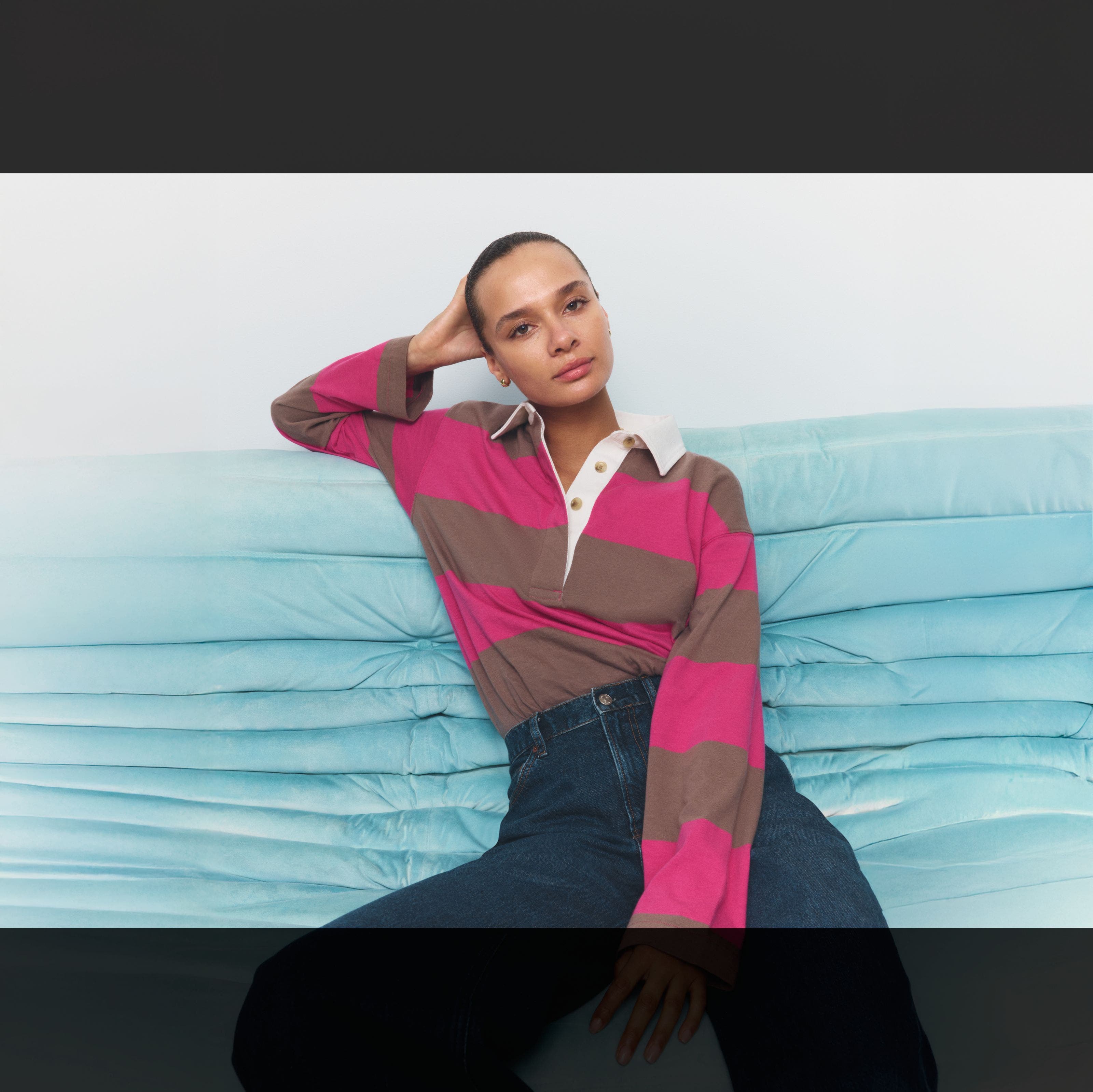 A woman wearing a striped polo shirt.