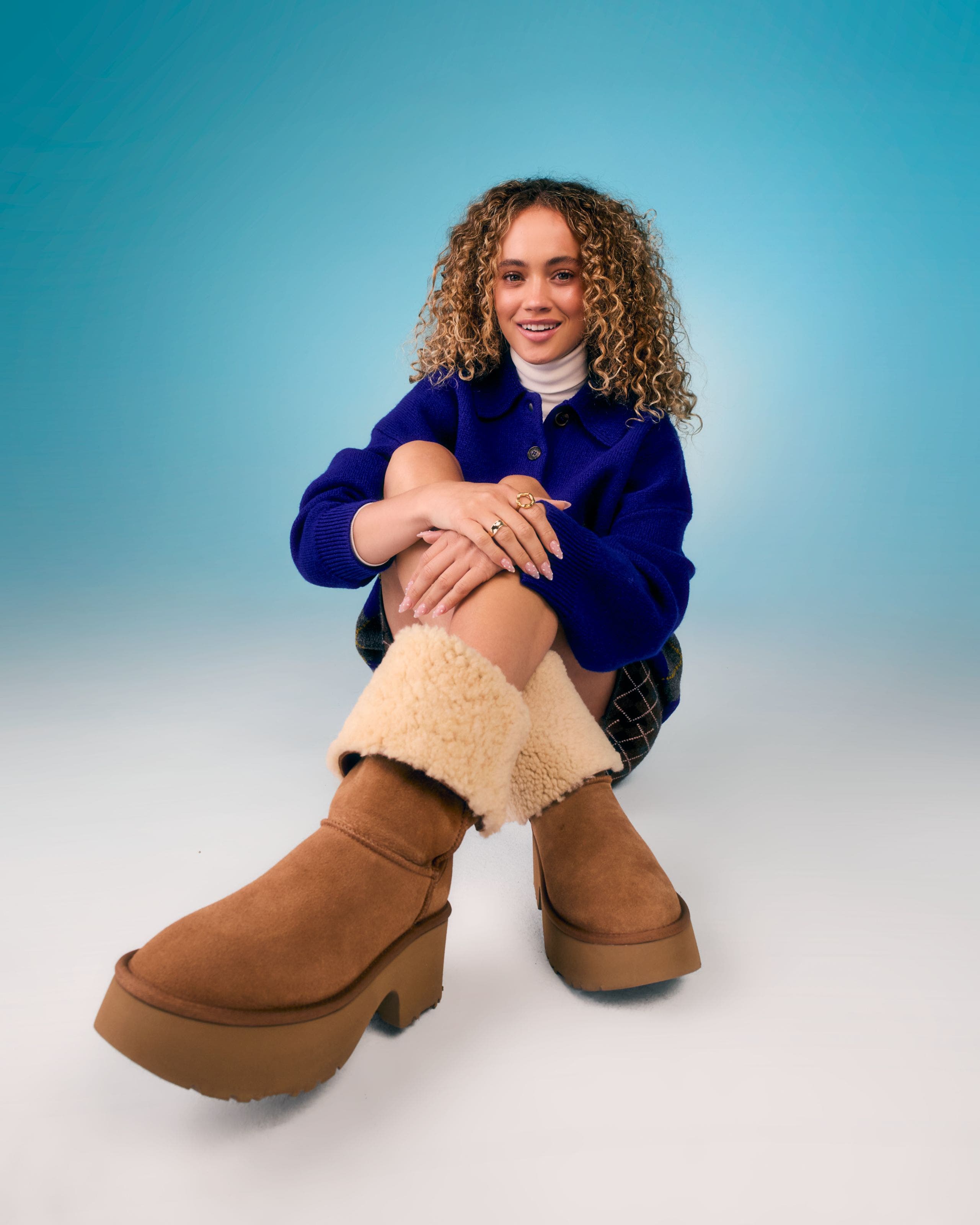 Woman wearing tan shearling-lined platform boots.