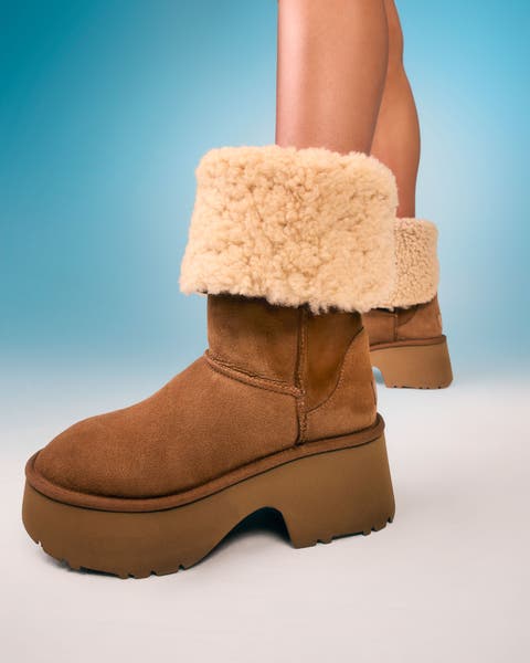 A woman wearing tan shearling platform boots.