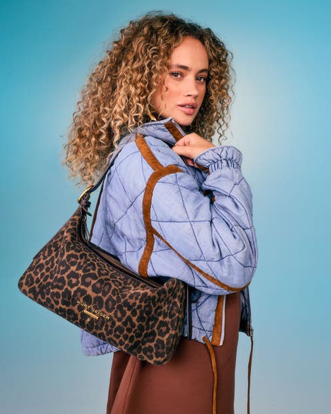 Woman in blue quilted jacket with a leopard print purse.