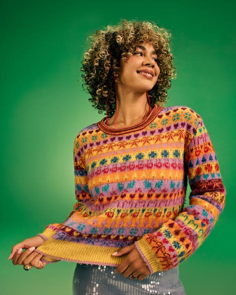 Woman in a colorful sweater with hearts and bows.
