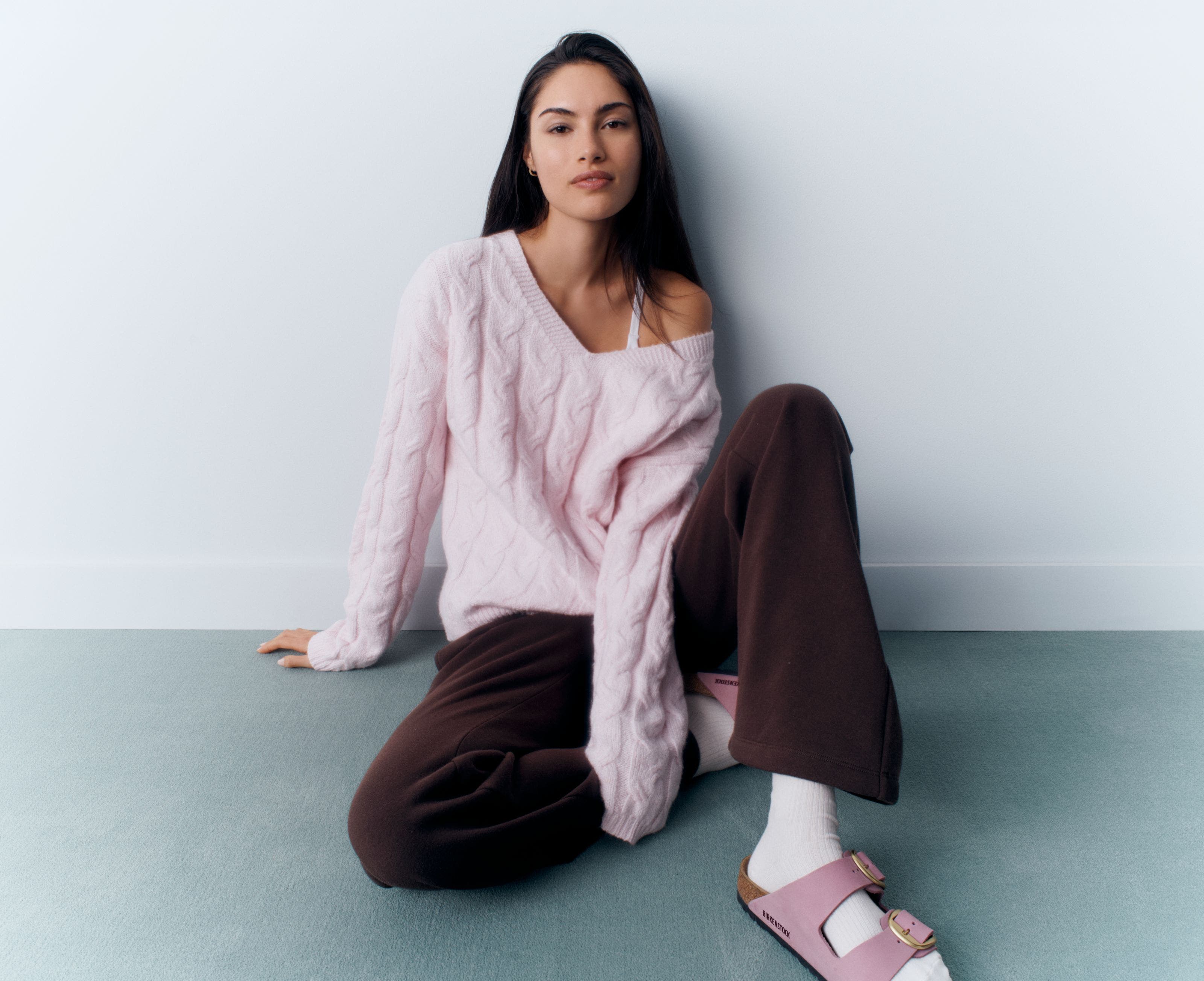 A woman in a pink cable-knit sweater.