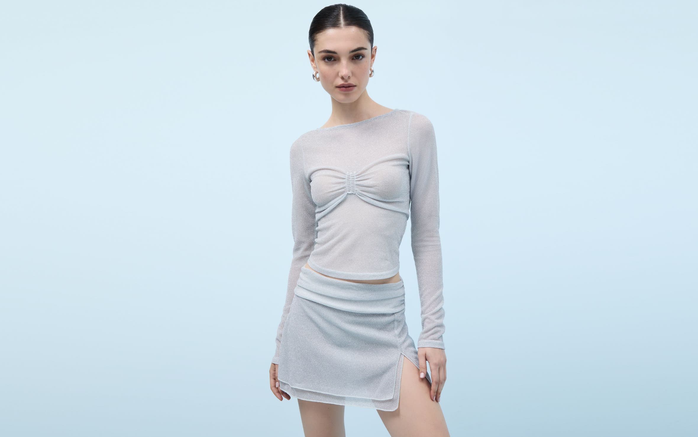 Woman wearing a sheer top and miniskirt.