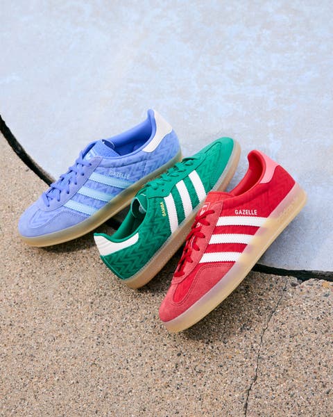 Three pairs of Adidas sneakers displayed on the ground.