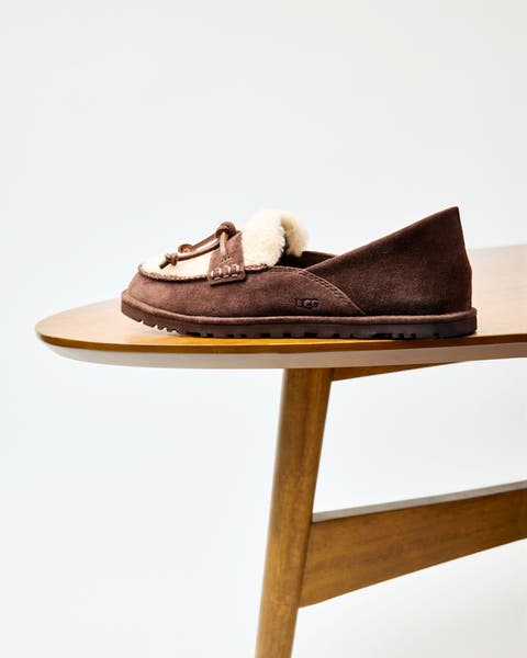 A pair of brown suede and shearling detail slippers. 