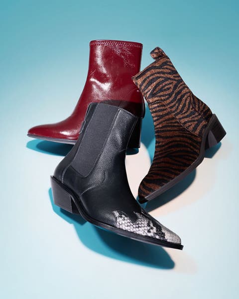 Three ankle boots arranged together in red leather, black snake print, and brown zebra print.