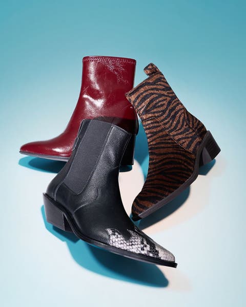 Three ankle boots arranged together in red leather, black snake print, and brown zebra print.