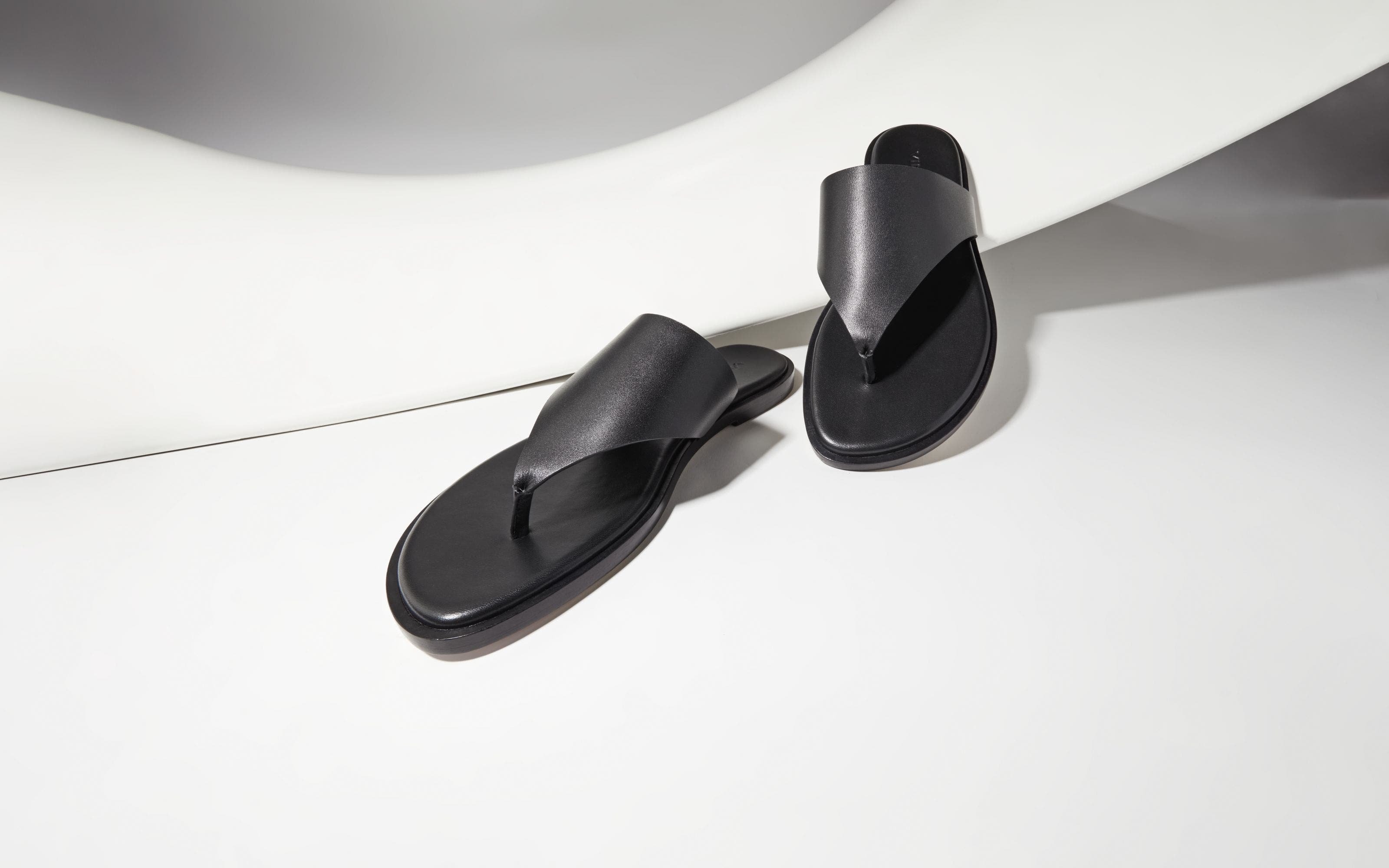 A pair of black thong sandals.