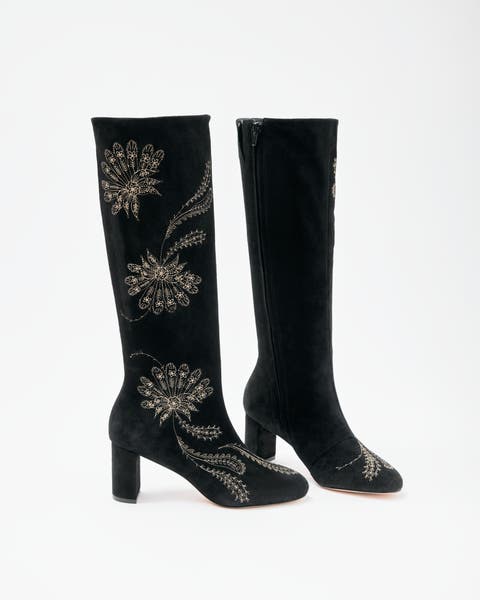 A product shot of tall black, embroidered boots.