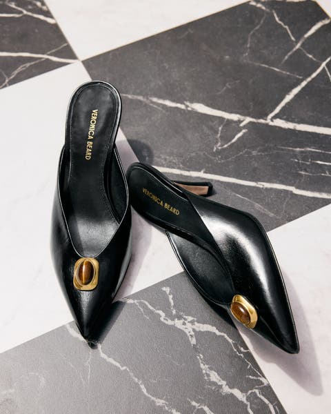 A pair of black shoes against a marble floor.