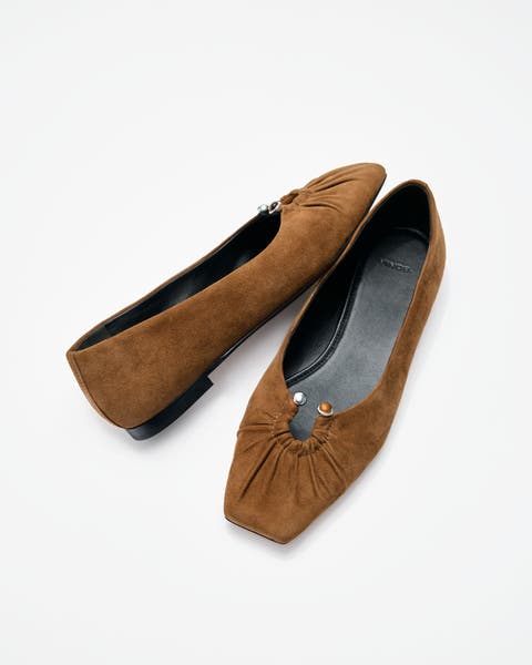 A pair of olive-green suede flats.