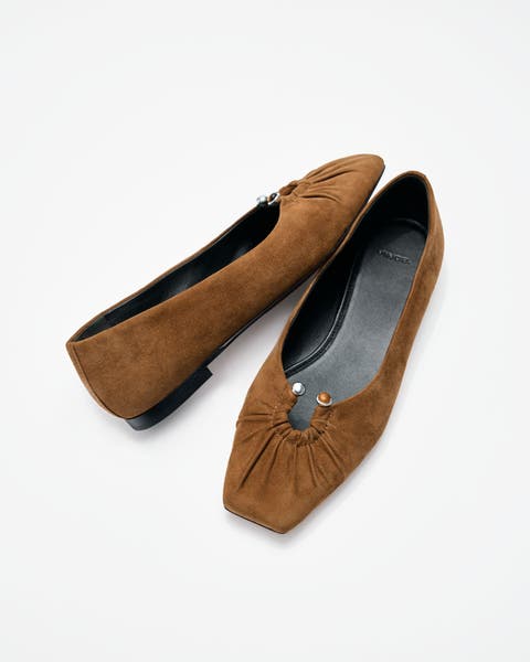 A pair of brown suede flats.