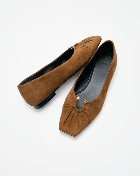 Brown suede flats with keyhole detail.