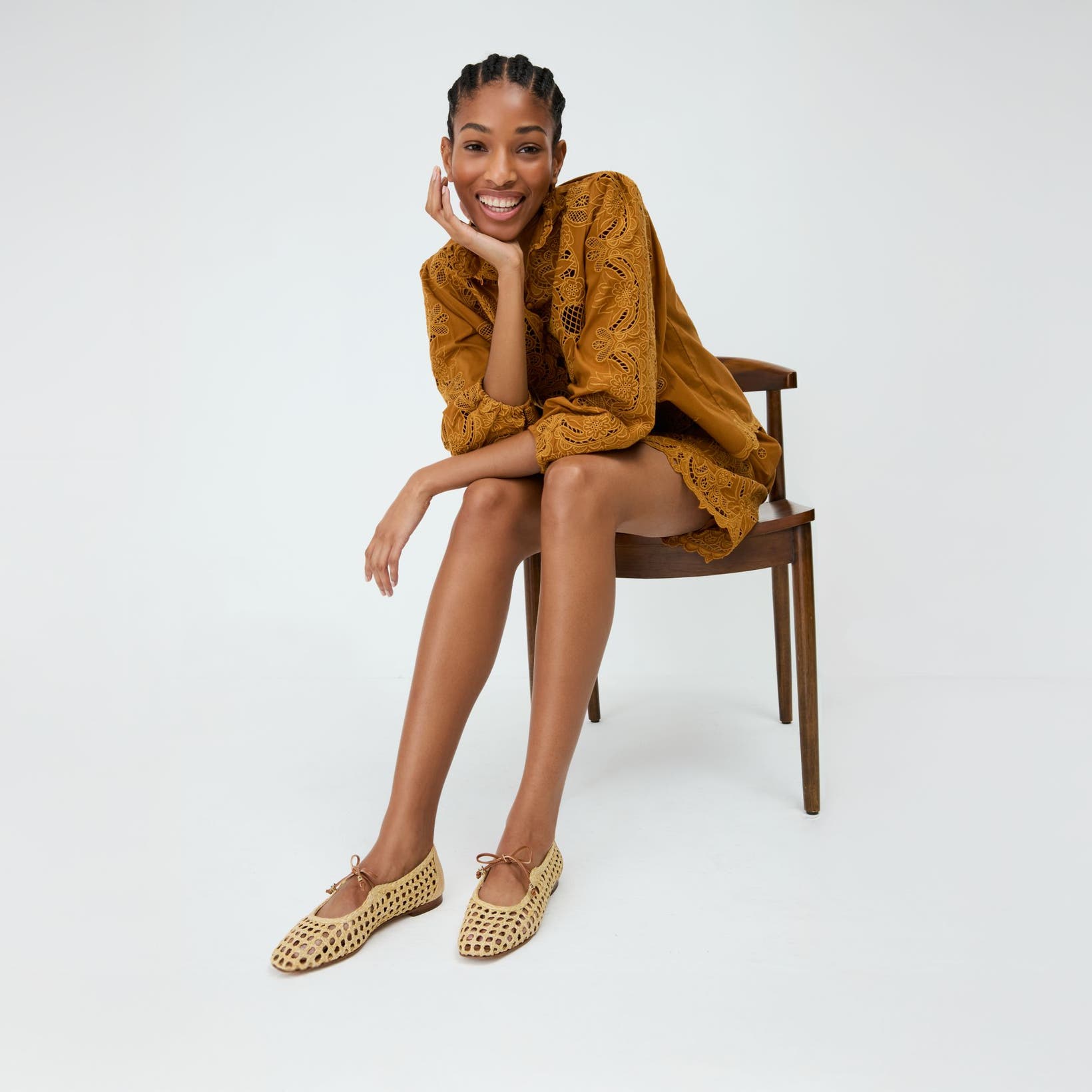 A woman wearing open-weave mary jane flats.