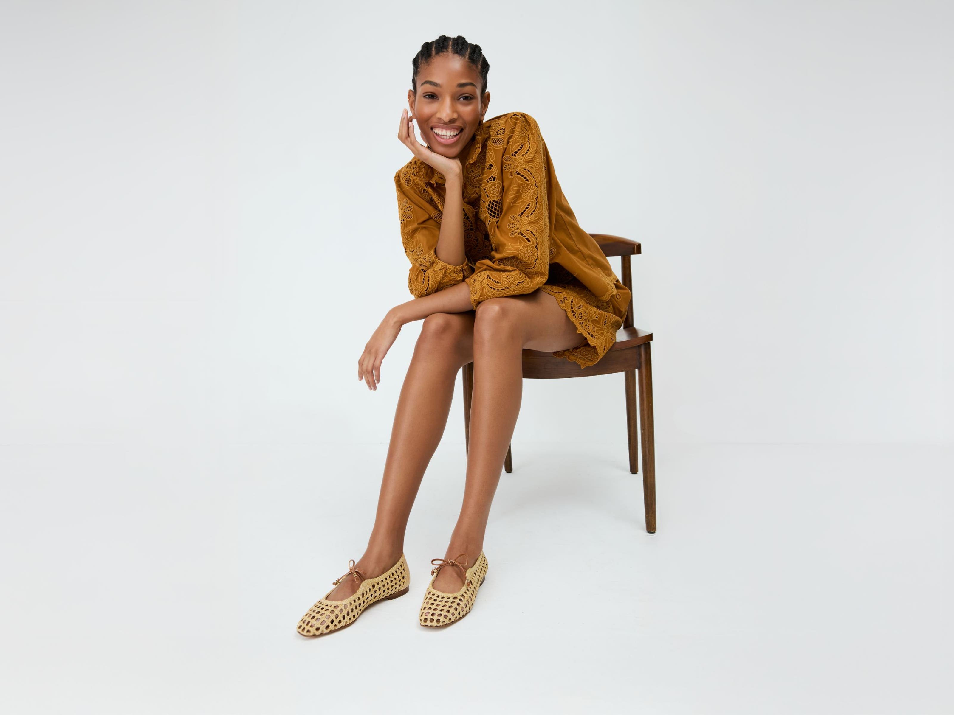 A woman wearing open-weave mary jane flats.