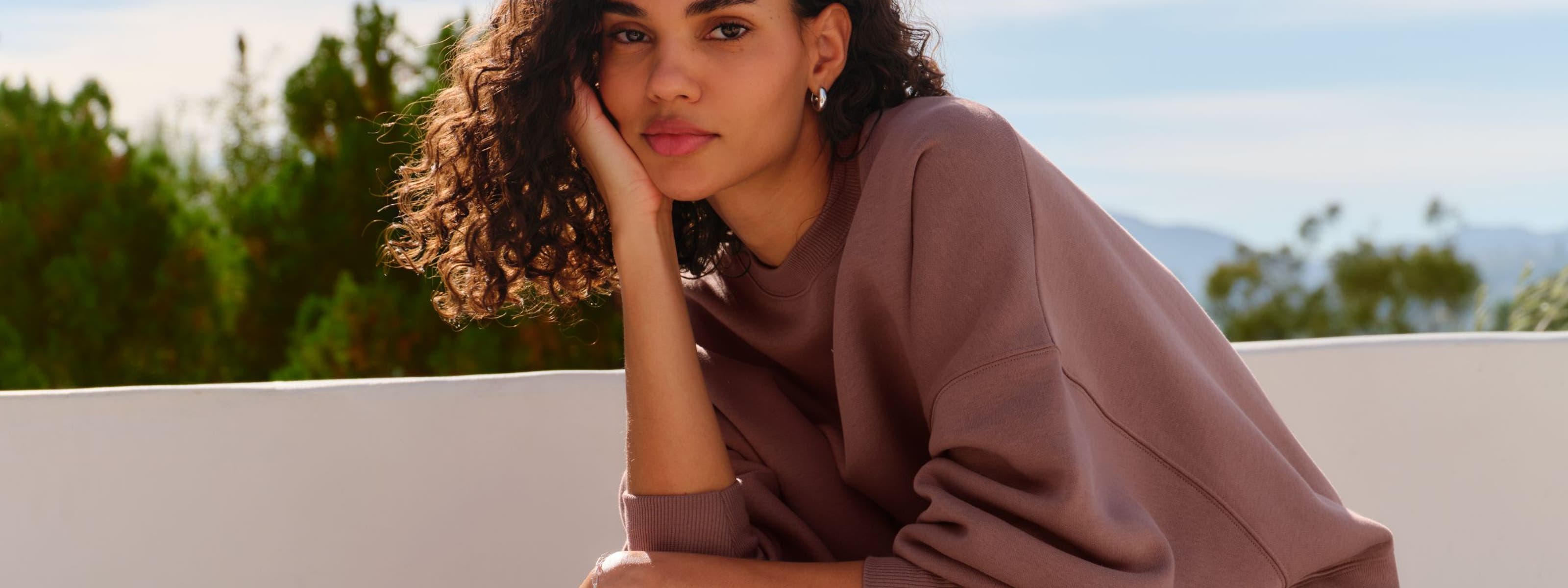 A woman sitting on a stone bench.