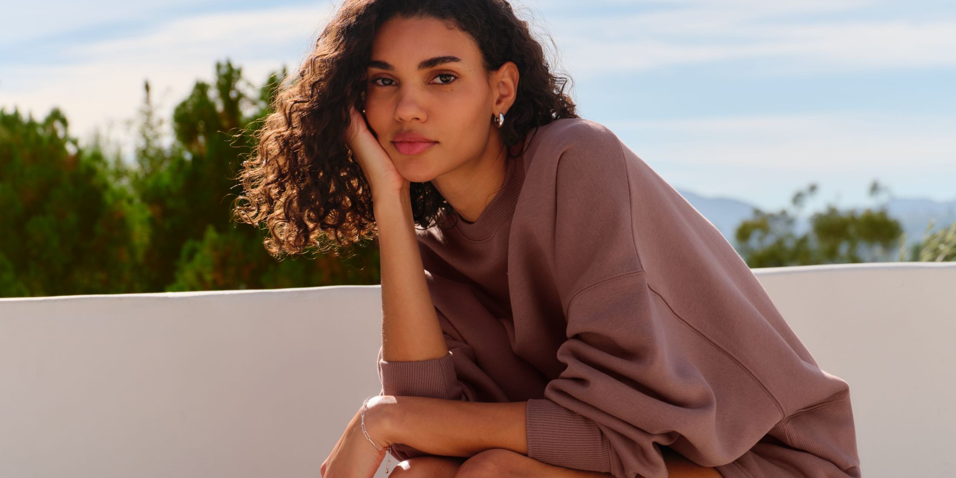 A woman sitting on a stone bench.