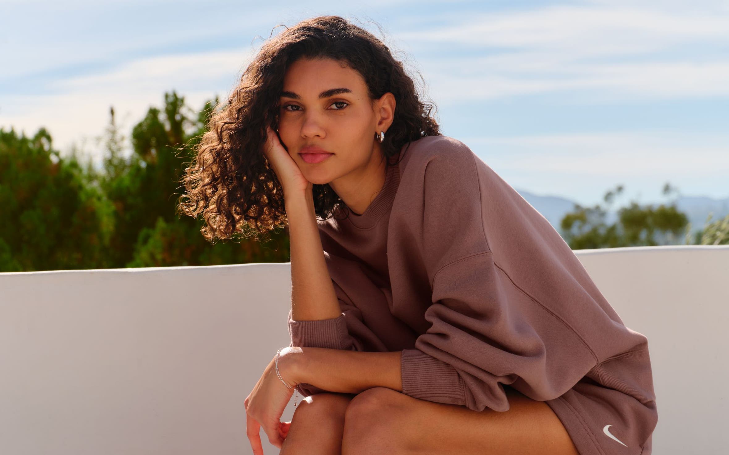 A woman sitting on a stone bench.