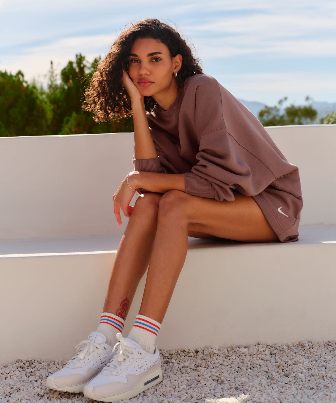 A woman sitting on a stone bench.
