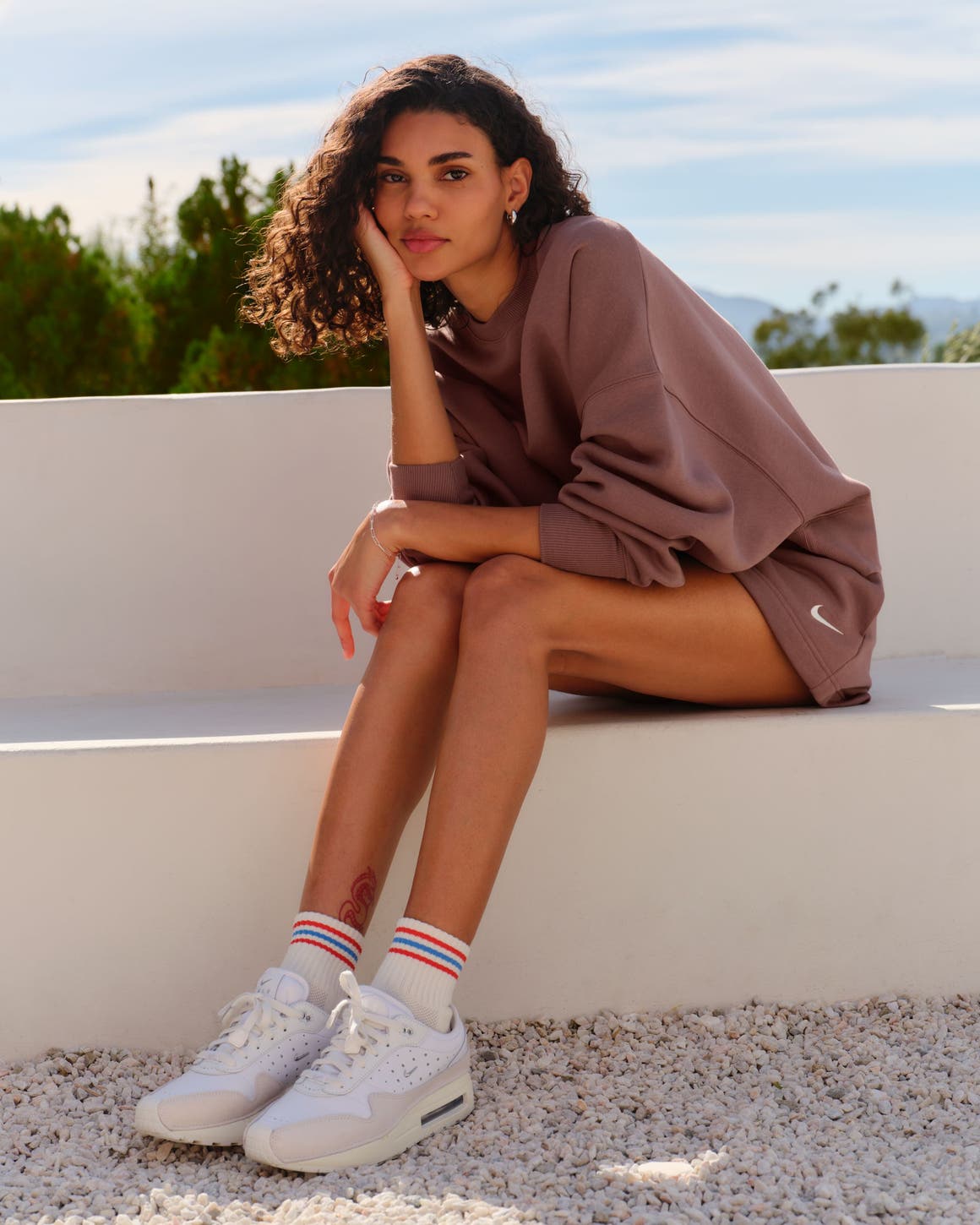 A woman sitting on a stone bench.